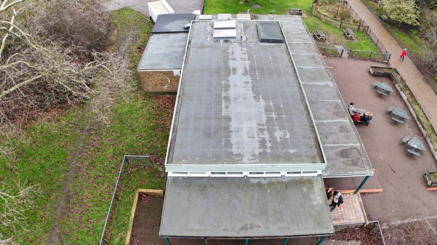 Image, taken from a drone, shows the roof and birds eye view of the building being surveyed. 