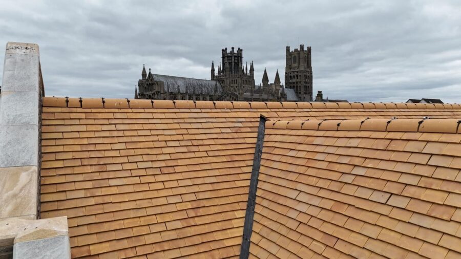 Image of a roof close up, captured by a drone during a building survey with a cathedral in the background.